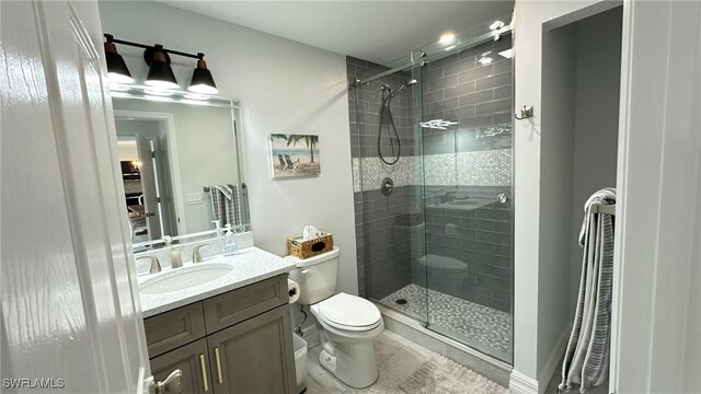full bath featuring vanity, toilet, tile patterned floors, and a stall shower