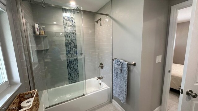 bathroom with baseboards and bath / shower combo with glass door