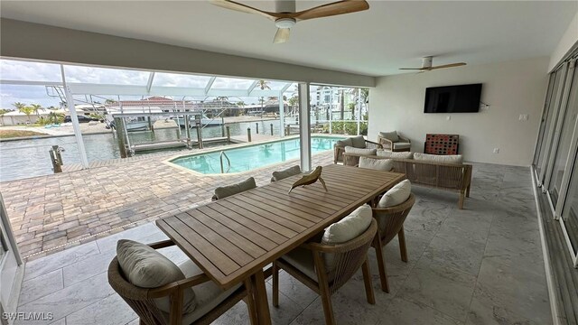 outdoor pool featuring boat lift, a patio, a dock, a water view, and a lanai