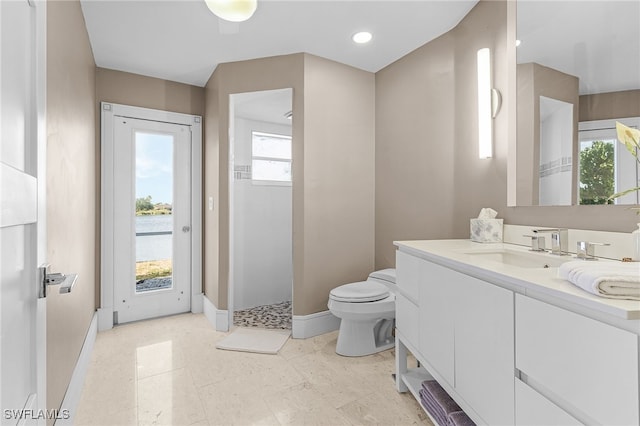 213 SE 6th St, Cape Coral, FL 33990 - bathroom featuring toilet, baseboards, a wealth of natural light, and vanity