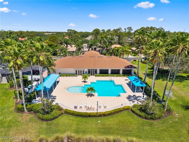 14790 Fripp Island Ct, Naples, FL 34119 - community pool featuring a patio area, a lawn, and view of wooded area