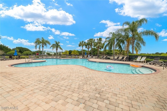 pool with a patio and fence