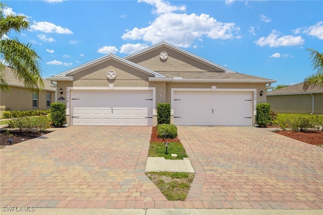 view of front facade featuring an attached garage, decorative driveway, and stucco siding