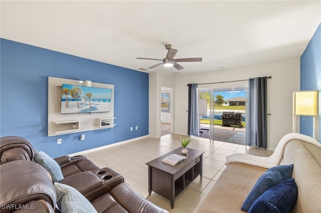 living area featuring tile patterned floors, ceiling fan, and baseboards