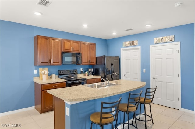 kitchen featuring light countertops, brown cabinetry, baseboards, visible vents, and black appliances