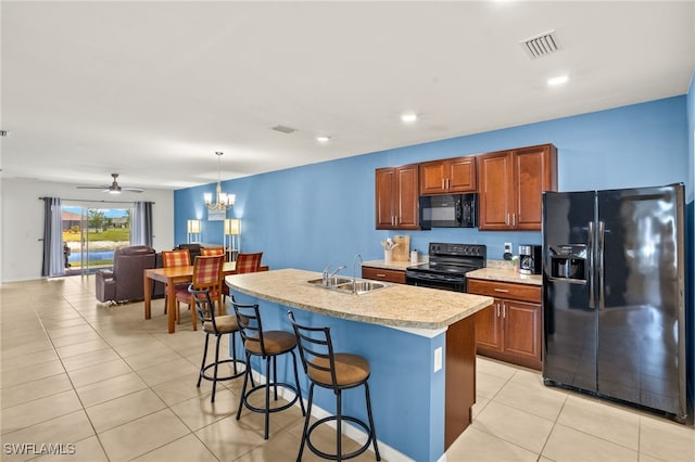 kitchen featuring light countertops, visible vents, a sink, and black appliances