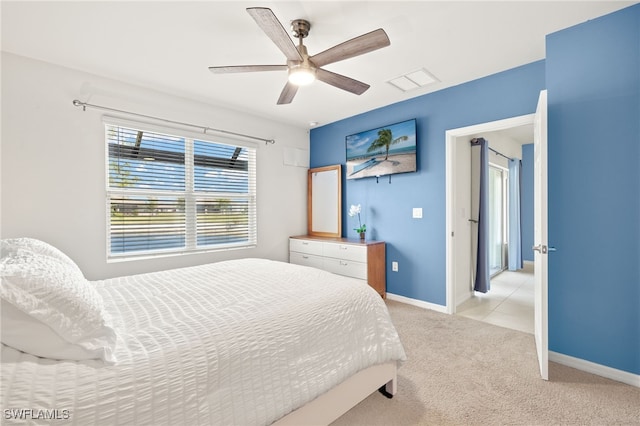 bedroom featuring light colored carpet, baseboards, visible vents, and a ceiling fan