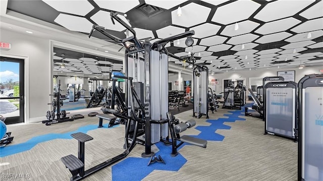 exercise room featuring baseboards and carpet flooring