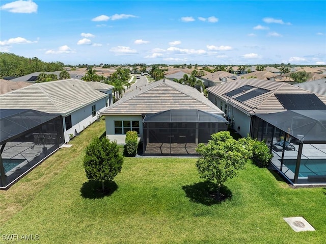 back of property with a lawn, a residential view, a lanai, and an outdoor pool