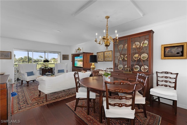 dining room with ornamental molding, a notable chandelier, and dark wood finished floors