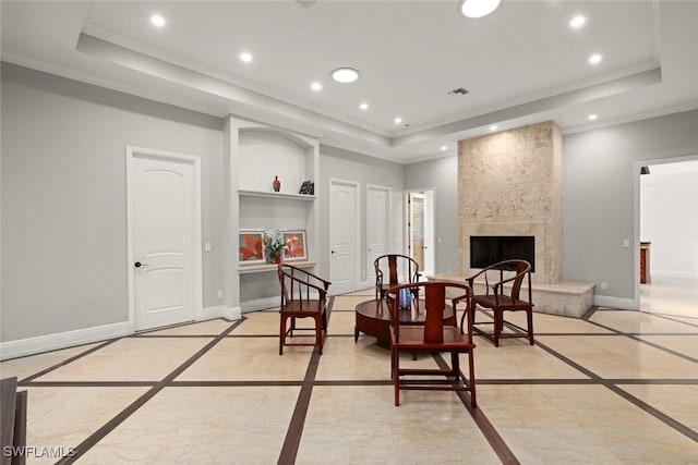 sitting room featuring recessed lighting, a tray ceiling, a tiled fireplace, and baseboards