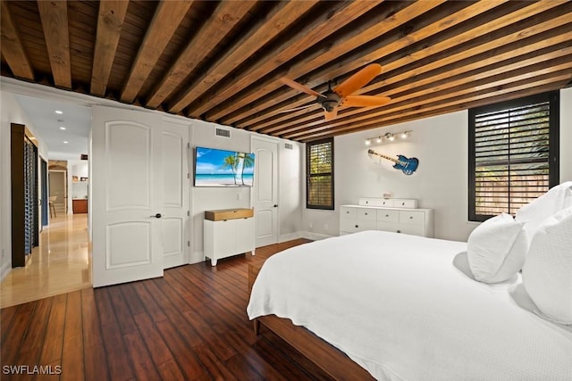bedroom featuring hardwood / wood-style floors, recessed lighting, baseboards, beamed ceiling, and visible vents