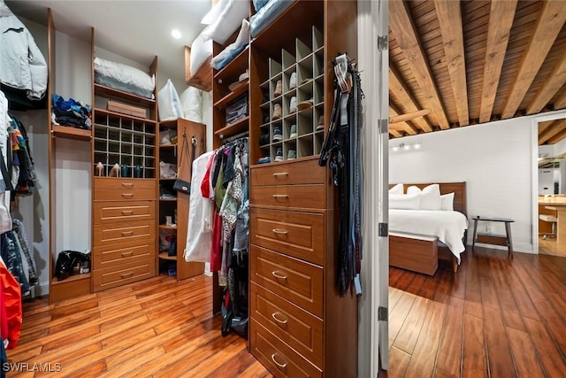 walk in closet with light wood-style floors