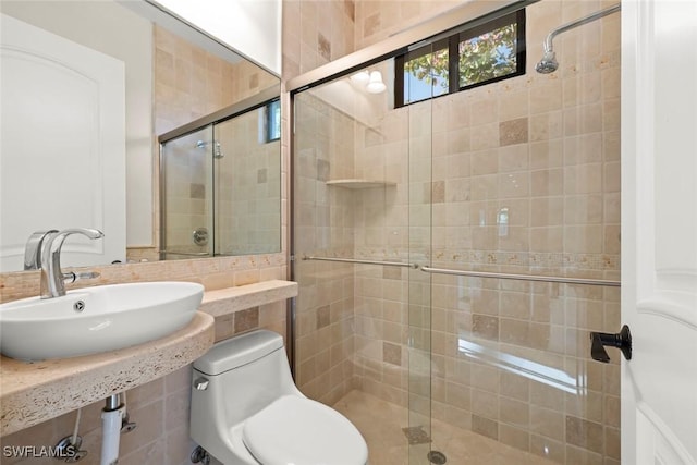 full bath with a sink, a stall shower, and toilet