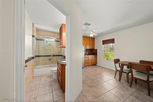 bathroom with vanity, tile patterned flooring, bath / shower combo with glass door, and visible vents
