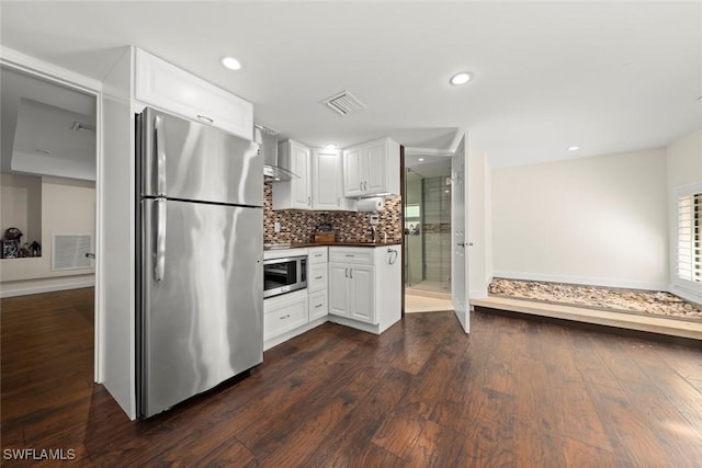 kitchen featuring visible vents, dark wood-type flooring, white cabinetry, tasteful backsplash, and appliances with stainless steel finishes