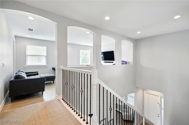 corridor featuring recessed lighting, an upstairs landing, and wood finished floors