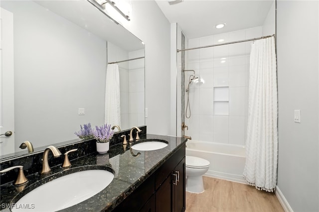 full bath with toilet, shower / bath combo, a sink, and wood finished floors