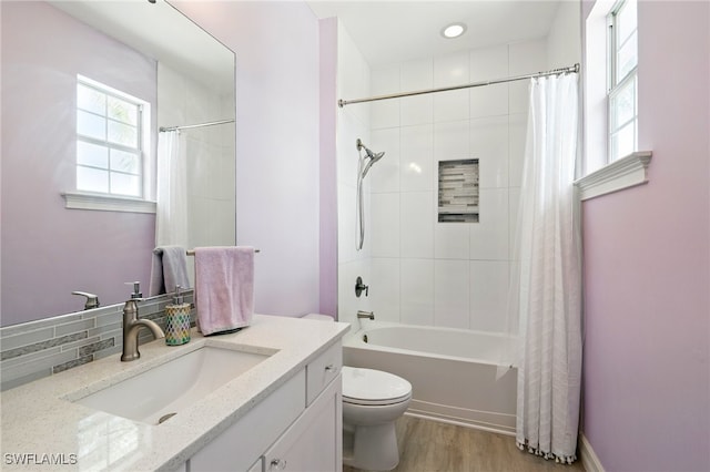full bath with toilet, shower / bathtub combination with curtain, wood finished floors, and vanity