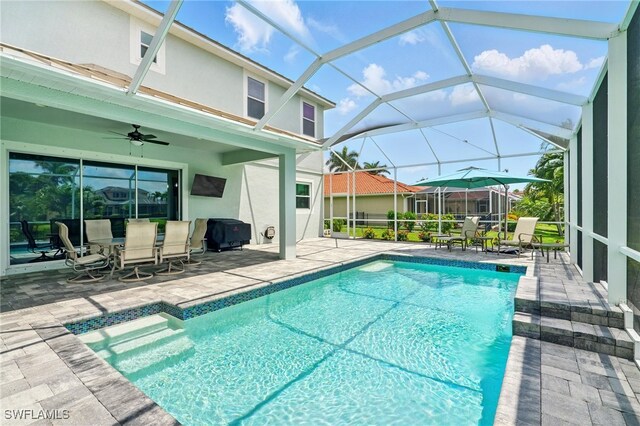 outdoor pool featuring a patio area, outdoor dining area, grilling area, a lanai, and ceiling fan