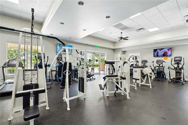workout area with a drop ceiling, ceiling fan, visible vents, a raised ceiling, and french doors