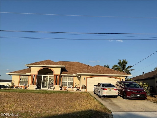 view of front facade featuring a garage, stucco siding, a front yard, and concrete driveway