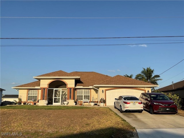 view of front of home featuring an attached garage, driveway, a front yard, and stucco siding