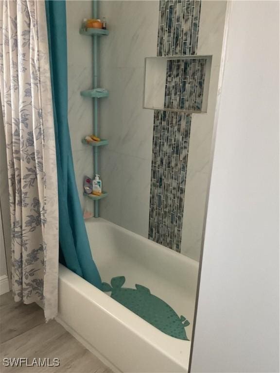 bathroom featuring wood finished floors and shower / tub combo