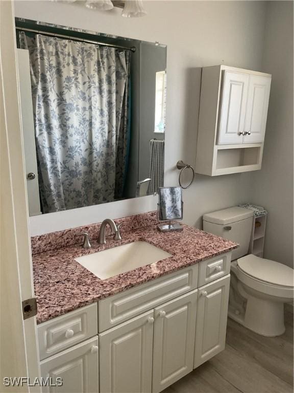 full bath with vanity, a shower with curtain, toilet, and wood finished floors