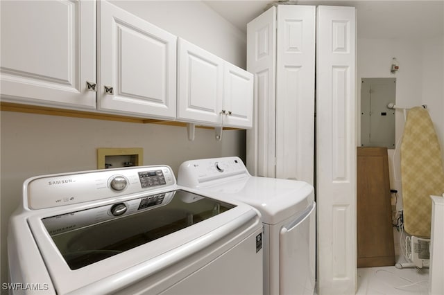 clothes washing area featuring separate washer and dryer, cabinet space, and electric panel