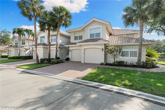 view of front facade featuring stucco siding, an attached garage, and decorative driveway