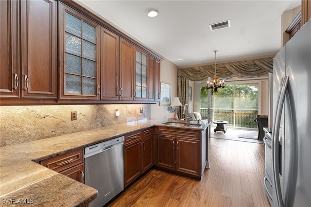 kitchen with dark wood-style flooring, appliances with stainless steel finishes, a sink, a chandelier, and visible vents