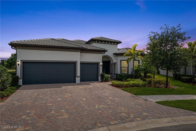 16166 Herons View Dr, Alva, FL 33920 - mediterranean / spanish-style house featuring a tiled roof, an attached garage, stucco siding, and decorative driveway