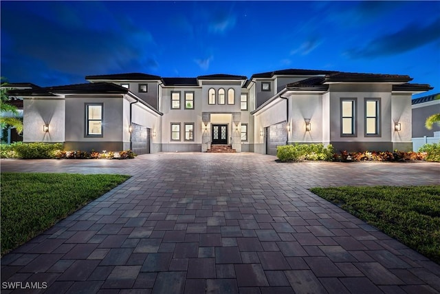3924 W Riverside Dr, Fort Myers, FL 33901 - view of front of house featuring stucco siding, decorative driveway, french doors, and a garage