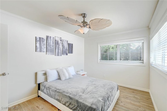 bedroom with light wood-type flooring, baseboards, ornamental molding, and multiple windows