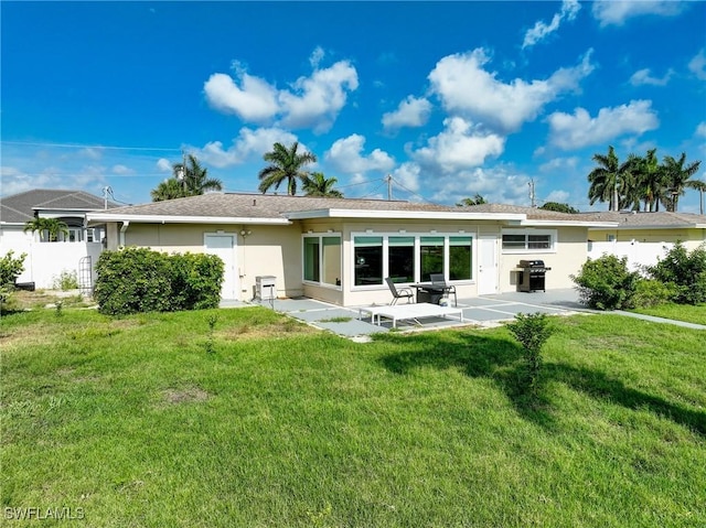 back of house featuring a lawn, stucco siding, and a patio area