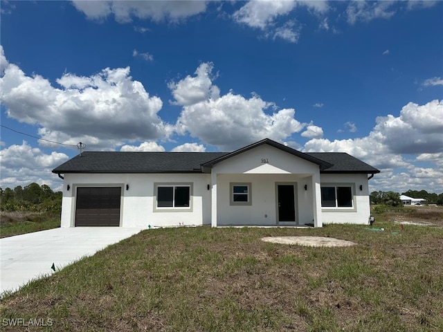 961 Countess Ave, Lehigh Acres, FL 33974 - view of front facade with an attached garage, driveway, stucco siding, and a front yard