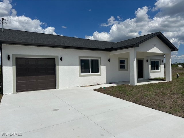 961 Countess Ave, Lehigh Acres, FL 33974 - view of front of home featuring an attached garage, concrete driveway, stucco siding, and roof with shingles