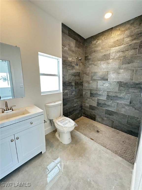 961 Countess Ave, Lehigh Acres, FL 33974 - bathroom with a tile shower, toilet, vanity, baseboards, and recessed lighting