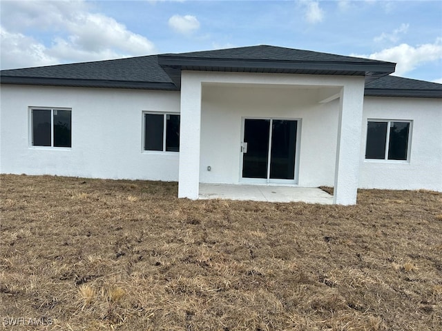 961 Countess Ave, Lehigh Acres, FL 33974 - rear view of property featuring a yard, a shingled roof, stucco siding, and a patio