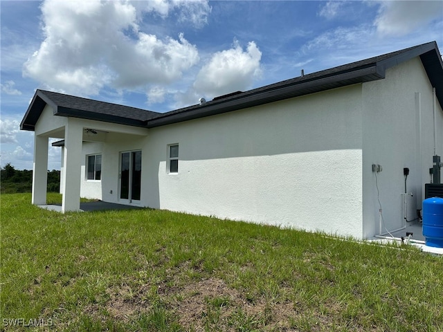 961 Countess Ave, Lehigh Acres, FL 33974 - back of property with stucco siding, a yard, and a patio