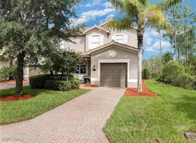 mediterranean / spanish-style home with a front lawn, stucco siding, and decorative driveway
