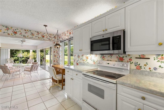 105 Wilderness Dr Unit B105, Naples, FL 34105 - kitchen with stainless steel microwave, light countertops, plenty of natural light, and white electric range