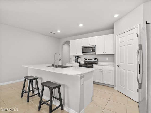 26480 Chaparel Dr, Bonita Springs, FL 34135 - kitchen with light tile patterned flooring, appliances with stainless steel finishes, a breakfast bar, a sink, and white cabinetry