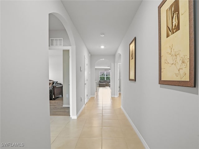 26480 Chaparel Dr, Bonita Springs, FL 34135 - hallway with visible vents, light tile patterned flooring, baseboards, recessed lighting, and arched walkways
