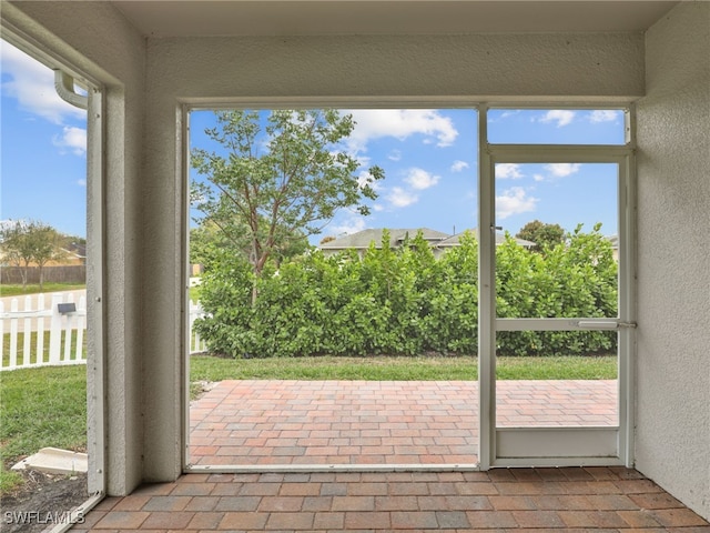26480 Chaparel Dr, Bonita Springs, FL 34135 - unfurnished sunroom with plenty of natural light, a textured wall, and brick floor