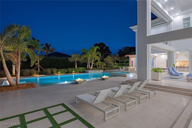 188 W St, Naples, FL 34108 - pool at night with a patio area and a pool with connected hot tub