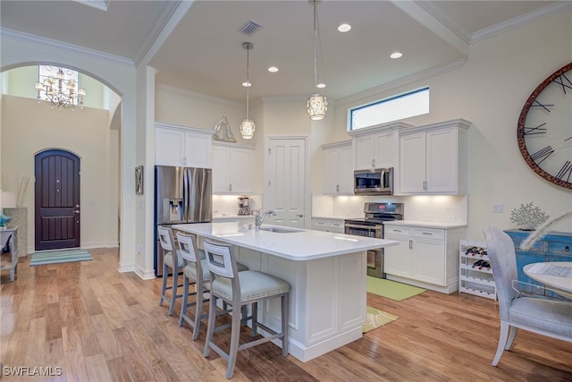 kitchen featuring stainless steel appliances, visible vents, a kitchen bar, arched walkways, and light countertops