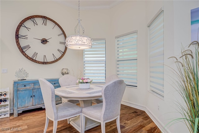dining area featuring crown molding, wood finished floors, and baseboards