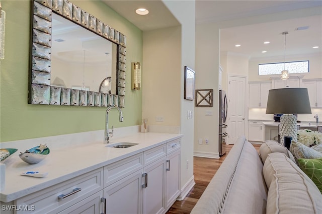 bathroom with vanity, recessed lighting, ornamental molding, and wood finished floors